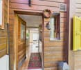 wooden exterior, open door, wooden floor, decorative rug, wall mounted light