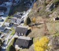 multiple buildings, small town, mountain setting, winding road, cars parked