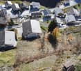 Aerial view of a village with multiple buildings, some with parking spaces, and some with garages