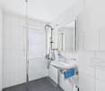 modern, white tiled walls, glass shower, sink, mirror, tile floor, drain
