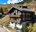 Detached chalet, wooden exterior, two floors, wooden balconies, large windows, chimneys