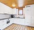 modern kitchen, white cabinets, wooden ceiling, tiled floor, electric stove, dishwasher, sink, window