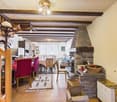 dining area with dining table, chairs, fireplace, living room with couch, TV, cabinet, power outlet, wooden floor, wooden staircase, lamps