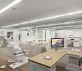 Interior space resembling a modern dental clinic with hardwood floors, various dental chairs, computers, cabinets, and shelves. A distinct feature is a monitor displayed prominently with a mountain landscape.
