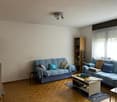 two sofas with pillows, coffee table, bookcase, window, wooden flooring, flat screen TV