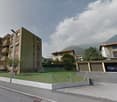 Apartment building with several balconies, a car parked in the garage