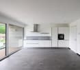 modern kitchen with white cabinets, gray tiled floor, large windows, and a view of the outside