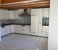 white cabinetry, tiled flooring, white walls, stainless steel appliances, wooden ceiling, open layout