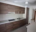 wooden cabinets, electric cooktop, sink, faucet, white tiles, overhead lighting