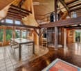 modern interior with wooden beams, open floor plan, central dining table, windows