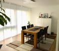 dining table with 6 chairs, white walls, white curtains, white cupboard, plants on the cabinet