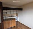 Kitchen with cabinets, counter, open refrigerator, tiled floor, wall, beam, stove, sink, faucet