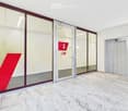 Marble floor, glass doors, elevator, red sign with number 1