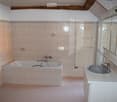 Bathroom with bathtub, sink, mirror, and towel radiator