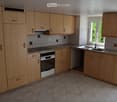 modern kitchen, tile flooring, wooden cabinets, sink, gas stove, oven, dishwasher