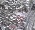 Urban neighborhood with multiple residential and commercial buildings. A construction site indicated with a red circle.