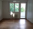 empty room, glass door, balcony, windows, hardwood floor, radiator