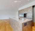 modern kitchen, steel countertop, built-in cabinets, wooden floors, large sink with faucet, mirror