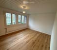 empty room, wooden floor, three large windows, white walls, radiator