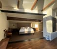 modern style bedroom, double bed, wooden ceiling, hardwood floor, wooden bench, desk and chair, wooden closets