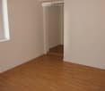 Empty room, white walls, wooden floor, small window