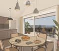 a table with 4 chairs, bowl of oranges, a round table, books, headphones, a counter with a sink, cabinets