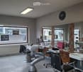Empty room, barber shop, two barber chairs, mirrors, wooden cabinets, sinks, ceiling lights