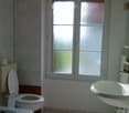 White toilet, bathtub, double sink, white tile walls, window