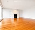 Unfurnished Room. Empty room with polished hardwood flooring, white walls, recessed lighting, and a fireplace with built-in shelving.