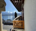 balcony with wooden railing, view of a lake and mountains