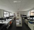 modern office space with white walls, black floors, multiple desks, computer monitors, chairs, cabinets, and lamps