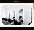 modern salon with white walls, black chairs, mirrors, tables, and ceiling lights