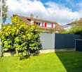 Well-maintained grass lawn with plants and a wooden fence