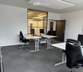 empty office room with desks, chairs, and monitors