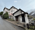 2 story house, stone and brick, brown garage, black door, mountain view