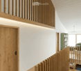 wooden door, wooden railing, white walls, wooden ceiling, wooden floor, green bookshelf, white chair, white sofa