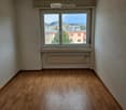 empty room, wooden floor, white walls, large window, view of the city