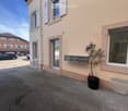 2 story house, beige exterior, white windows, mailboxes, potted plant, parking lot