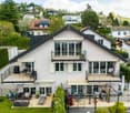 3 story house, white exterior, multiple balconies, solar panels, garden, outdoor seating, view of surrounding area