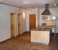kitchen with island, wooden cabinets, tiled floor, stainless steel appliances, wooden doors, track lighting
