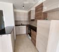 modern kitchen with wooden cabinets, black countertops, stainless steel appliances, tiled floor