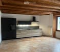 modern kitchen, black cabinets, tiled floor, wooden beams, double sinks, electric oven, microwave, window