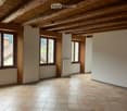 Exposed wooden ceiling, tiled flooring, windows, radiator