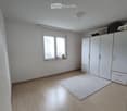 Unfurnished Room. Empty room with light wooden flooring, white walls, a large window with blinds, a white wardrobe, and a small white rug on the floor.