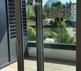 Balcony with tiled floor, large glass doors, and scenic mountain view.