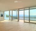 Unfurnished Room. Bright, empty room with light wooden flooring, large sliding glass doors leading to a balcony with a scenic mountain view.