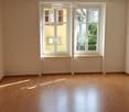 Unfurnished Room. Empty room with wooden flooring, large windows, and white walls.