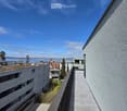Balcony / Terrace. Balcony overlooking a residential area with buildings, greenery, and a body of water in the distance.