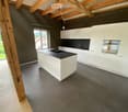 Kitchen. Modern kitchen with island, white cabinets, black countertops, and tiled floor.