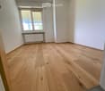 Empty room with wooden flooring, white walls, and a window with blinds. No furniture or equipment is present.